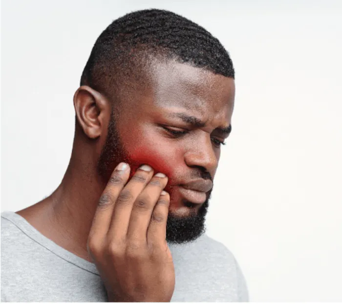 Man holding his cheek in tooth pain