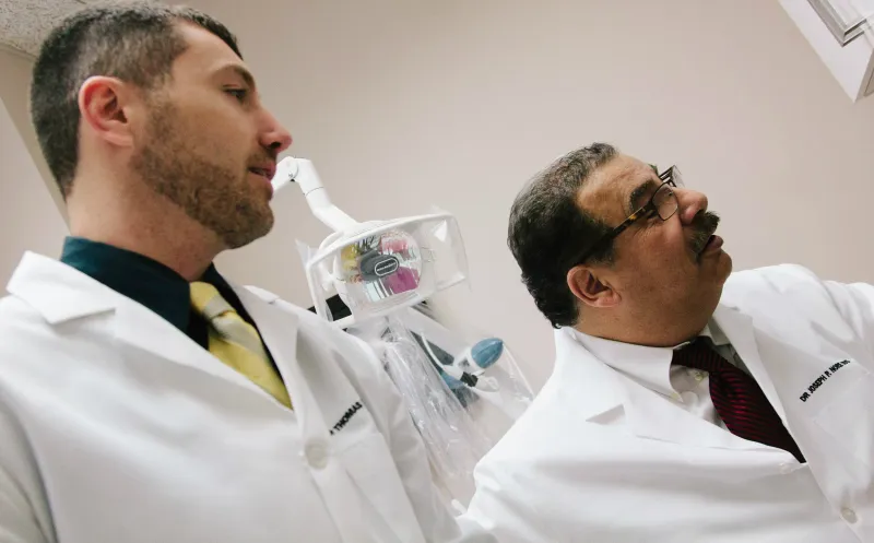 Two doctors reviewing a patient's smile